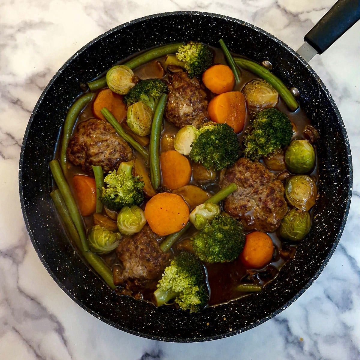 Step 13, a fully cooked Salisbury steak with vegetables, potatoes and thick mushroom gravy in one pan.