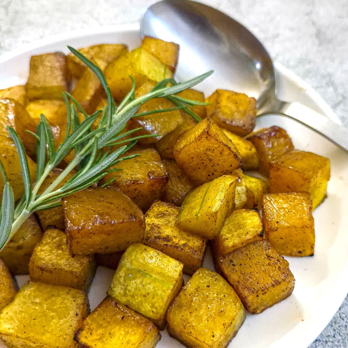 Close up of a plate of roasted butternut.cubes.