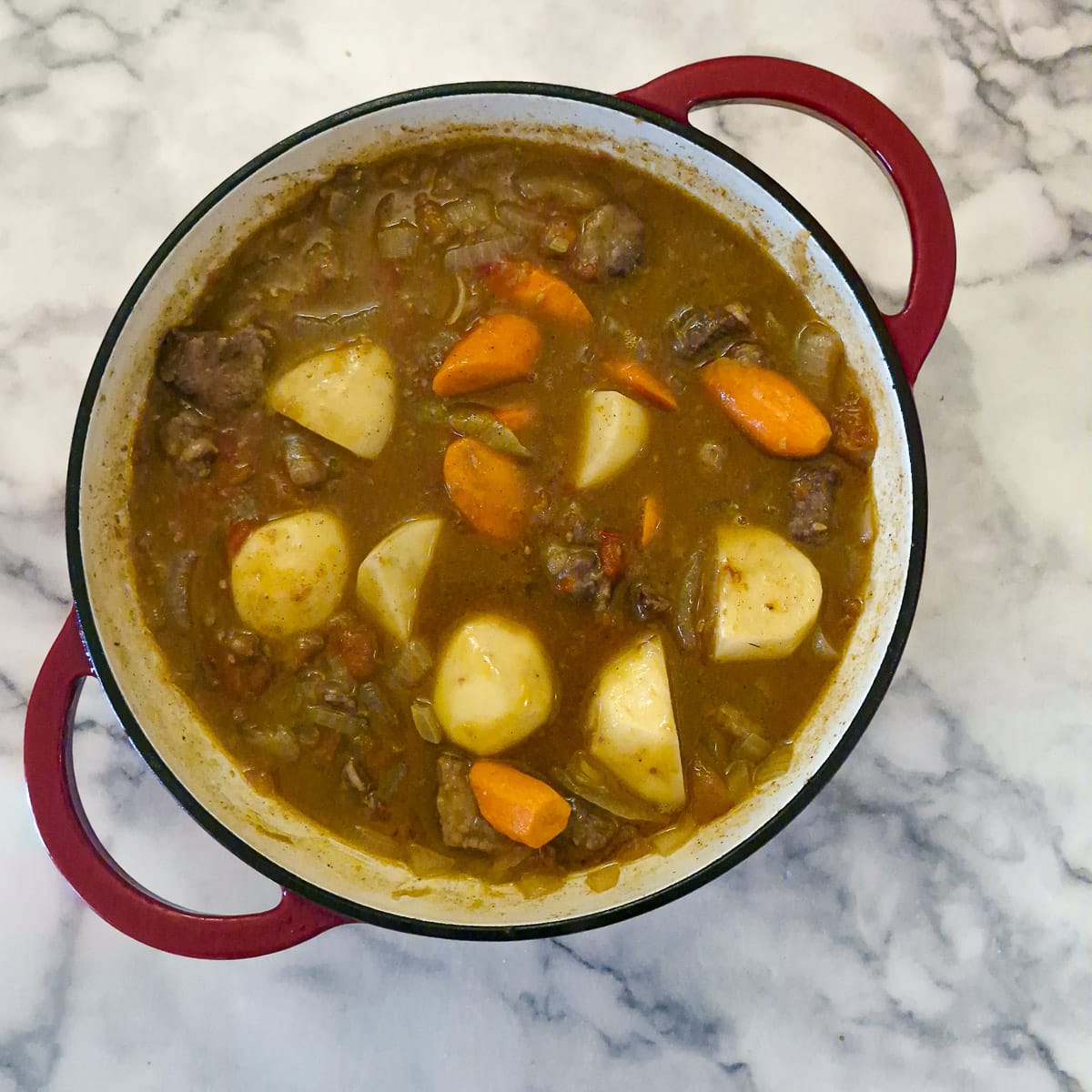 Step 7, potatoes and carrots added to the pan of bredie.