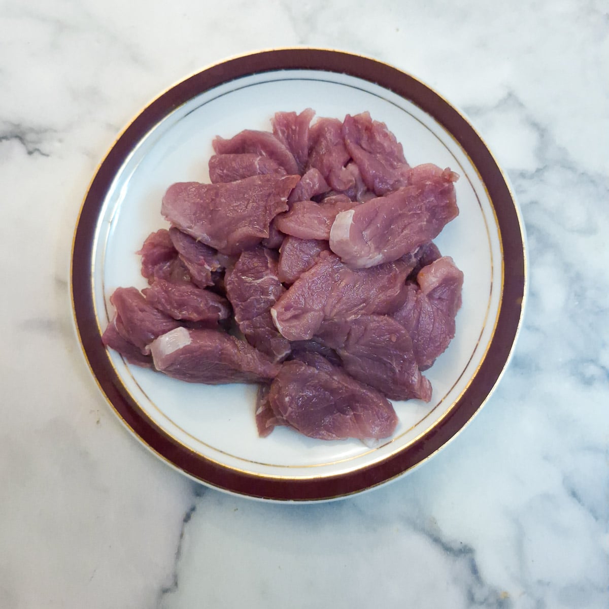 Thin slices of pork tendrloin on a snall plate.