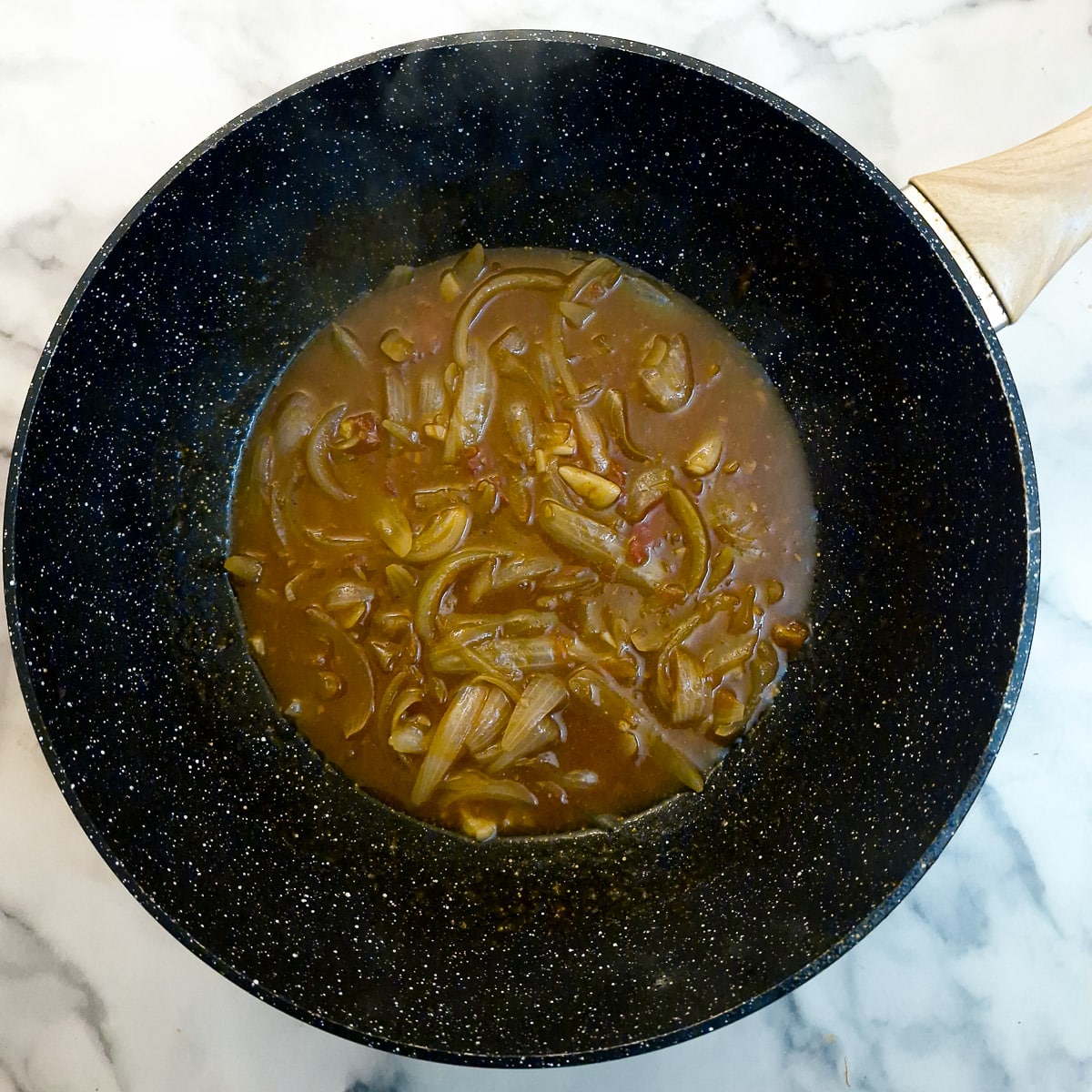 Stock and seasonings added to the tomatoes and onions.