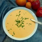 A dish of capsicum and tomato sauce garnished with chopped parsley.