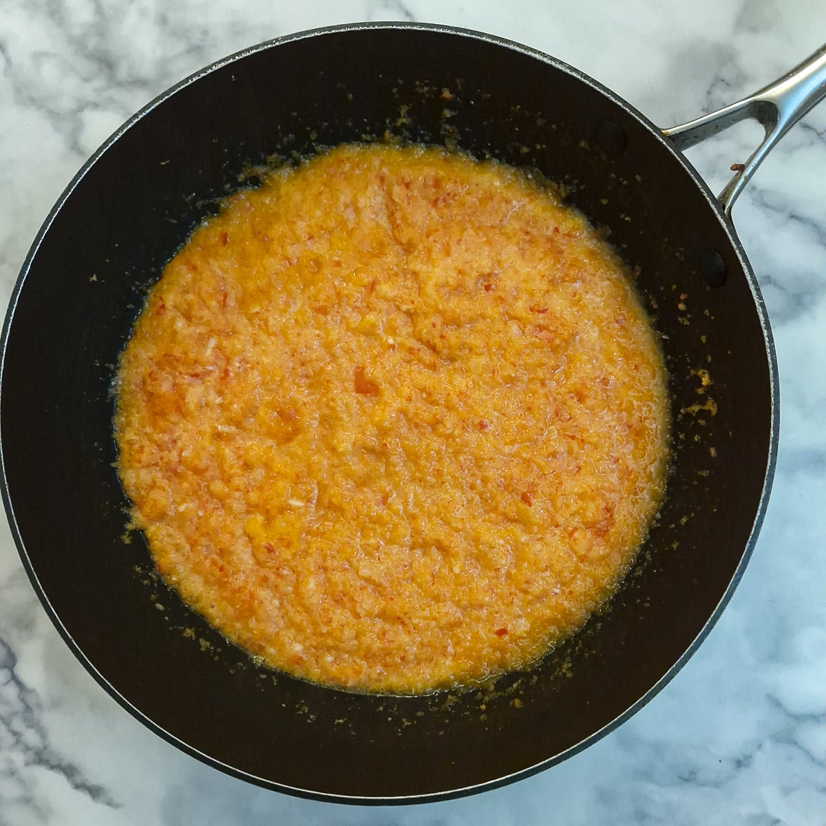 Step 2, blended onions and capsicum softening in a frying pan.