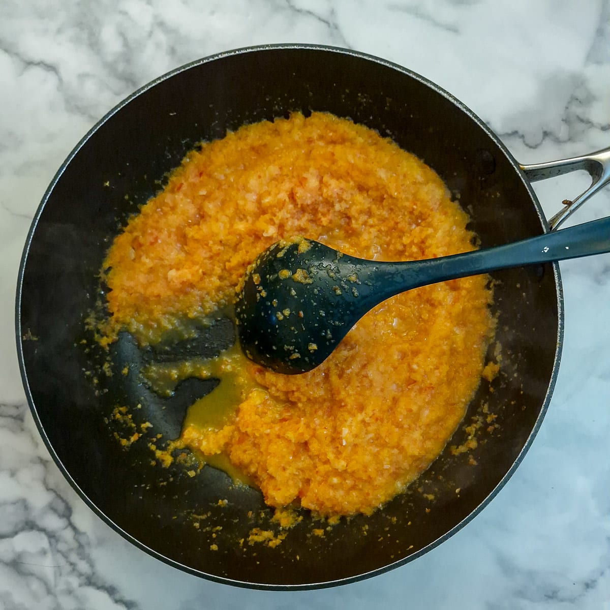 Step 3,softened onions and capsicum showing how they leave a trail when a spoon is drawn through them.