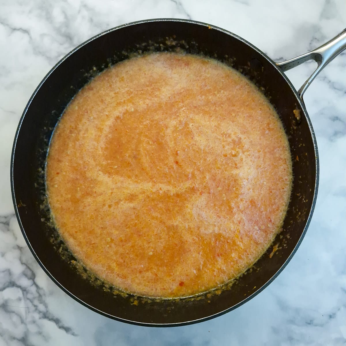 Step 5 blended tomatoes combined with onions and capsicum in a frying pan.