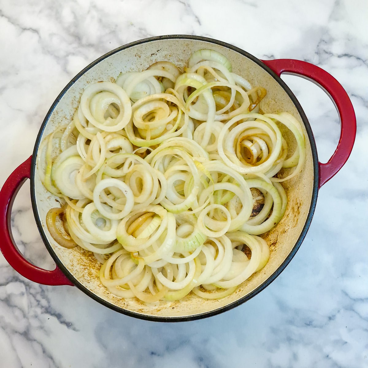 Slices of onions in a heavy casserole dish.