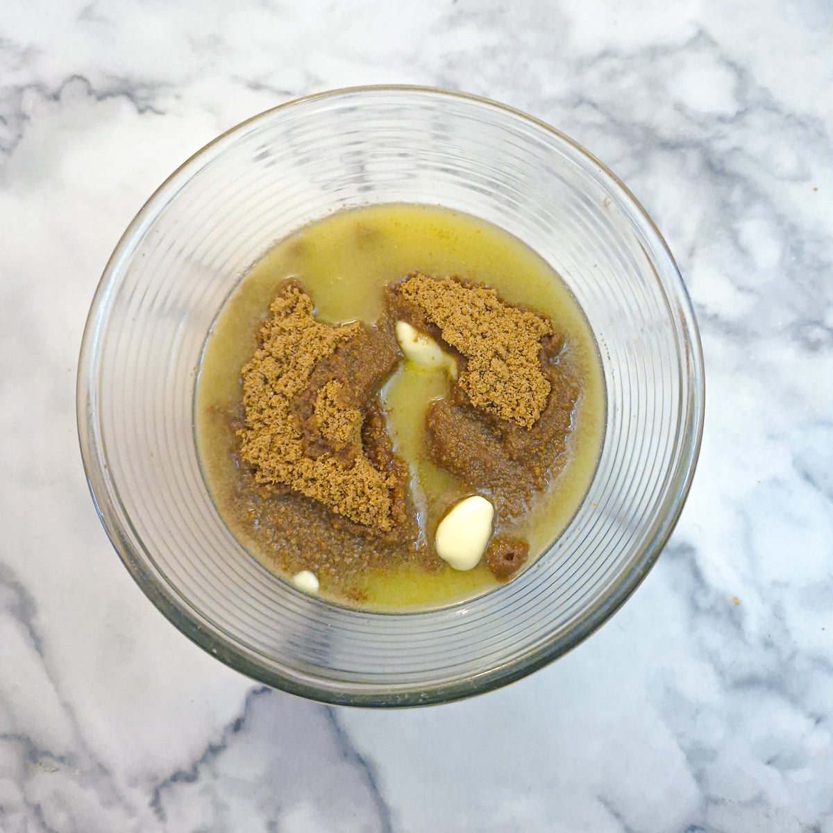 Ste[ 2 ginger biscuit crumbs and melted butter in a glass bowl.