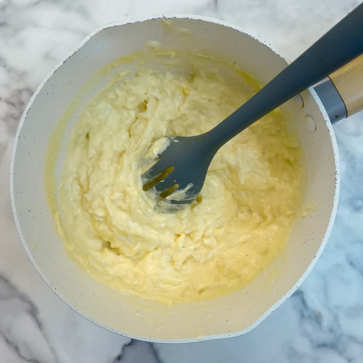 Step 8, grated pears being stirred into the custard.