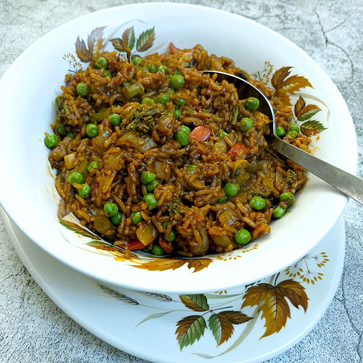 Sweet chilli vegetable rice in an autumn leaf-paterned white serving dish.