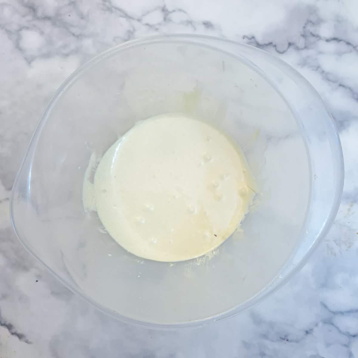 Eggs and sugar beaten together in a mixing bowl.