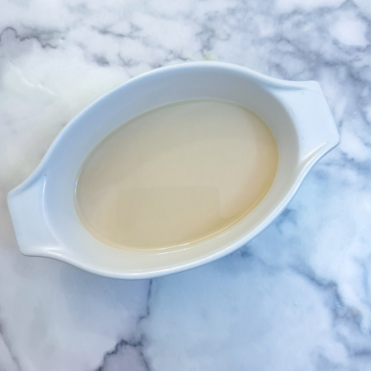 A small shallow bowl holding a mixture of Baileys and milk.