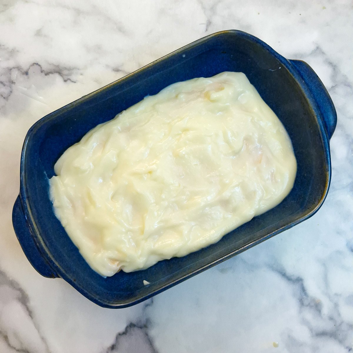 A layer of custard spread over the finger biscuits.