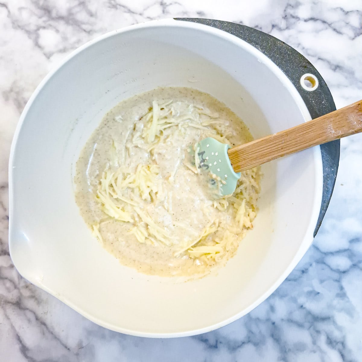 Grated apples being mixed into the batter.