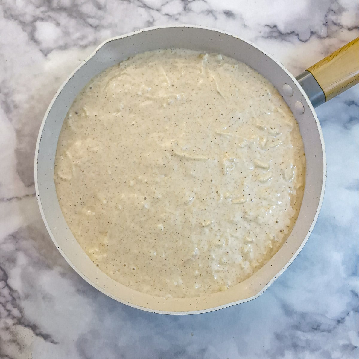 Apple cake batter poured over the sliced apples.