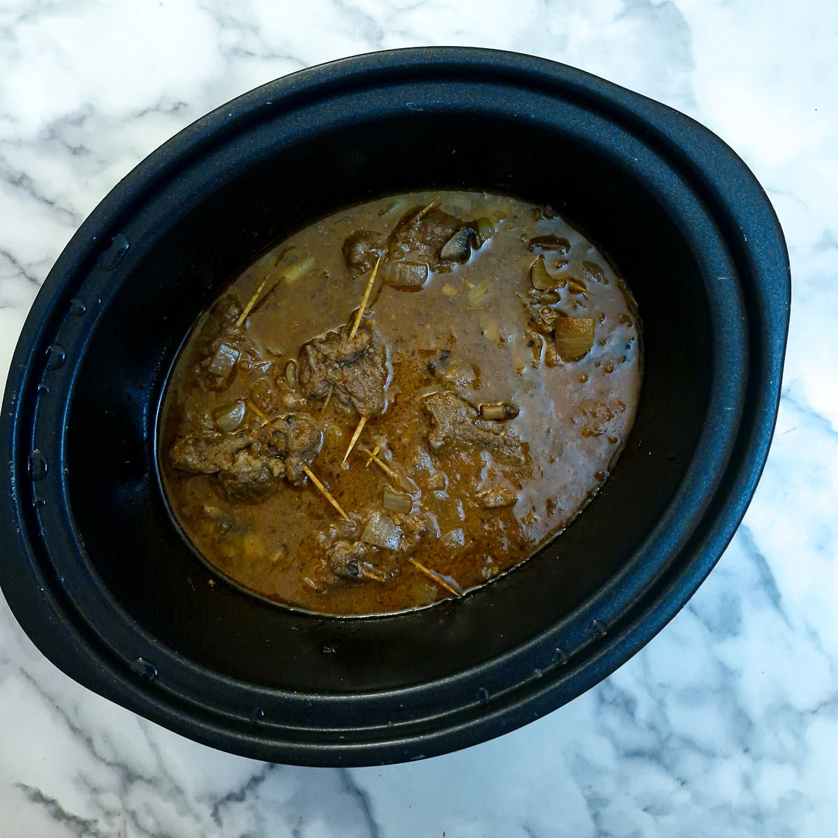 Step 10 - fully cooked beef olives in gravy in a slow cooker.