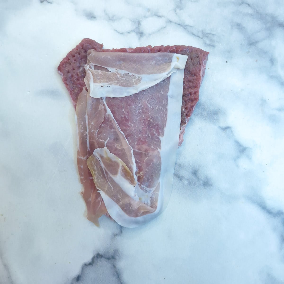 Step 5 - a slice of prosciutto arranged on top of a slice of beef.