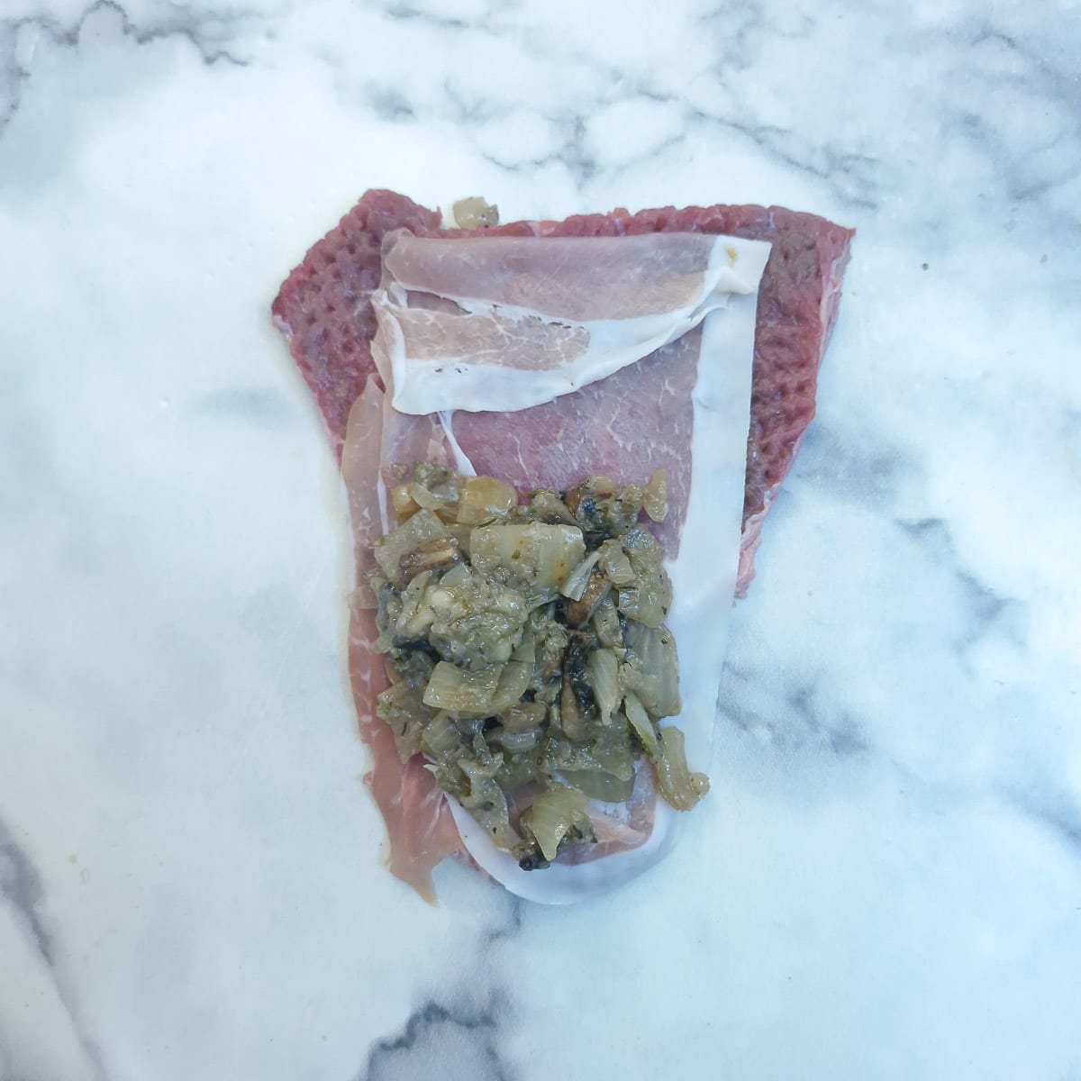 Step 6 - a tablespoon of mushroom and onion filling spooned onto the slice of beef.