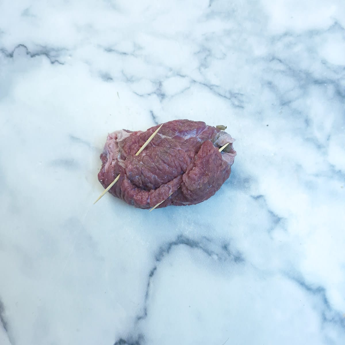 Step 7 - a fully assembled beef olive held together with toothpicks.