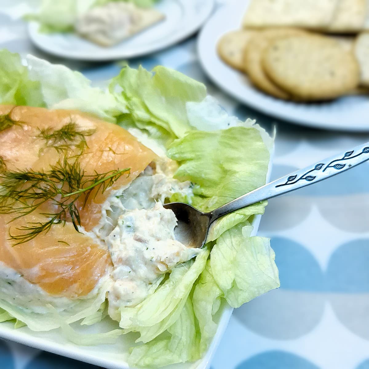 Easy salmon terrine on a plate. Some of the terrine is being spooned out.