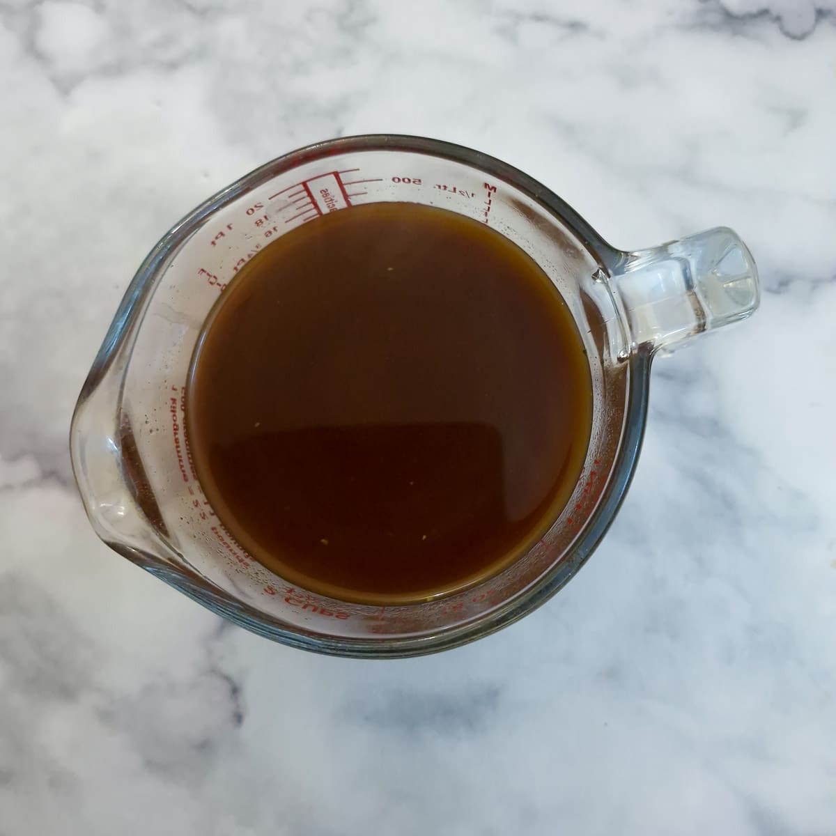 A glass jug containing the sauce ingredients.