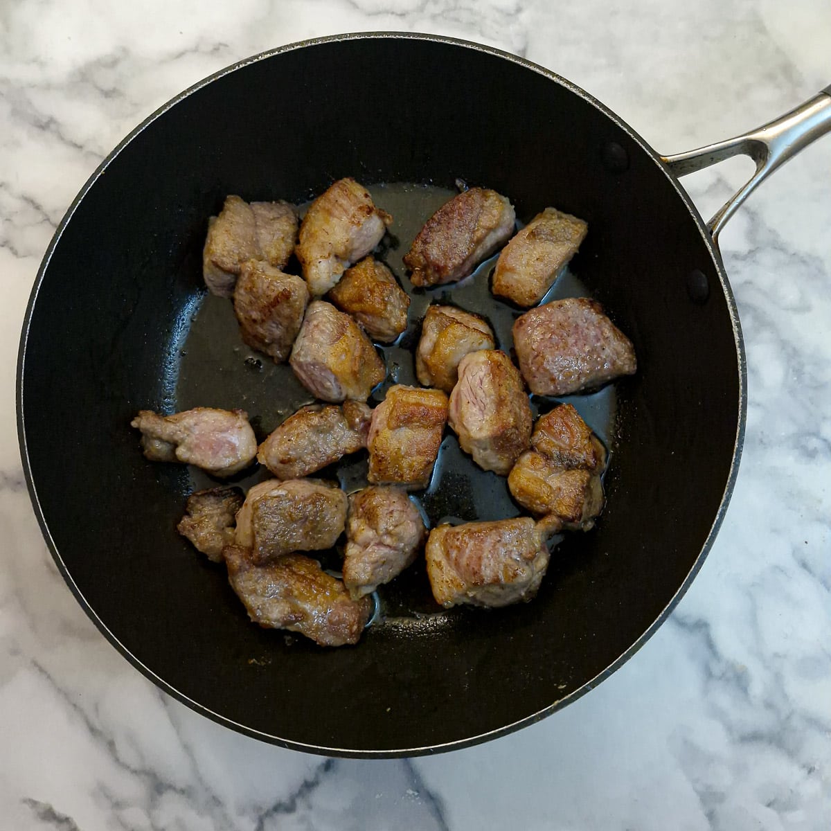 Step 2. Cubed lamb browing in a frying pan.