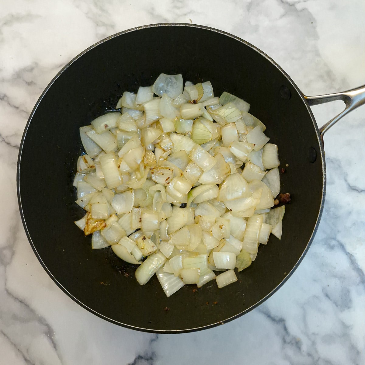 Step 3. Chopped onions softening in a frying pan.