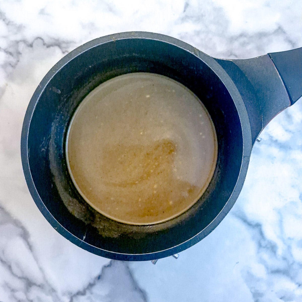 Step 8 - caramel sauce ingredients being heated in a saucepan.