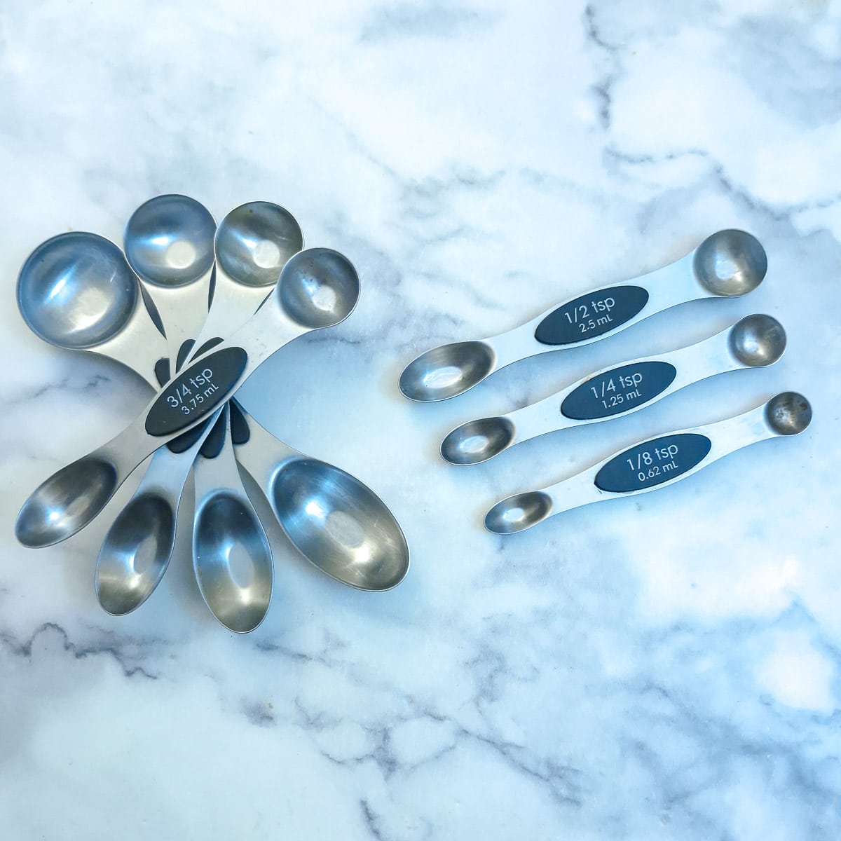 A set of double-sided magnetikc measuring spoons arranged on a work surface.