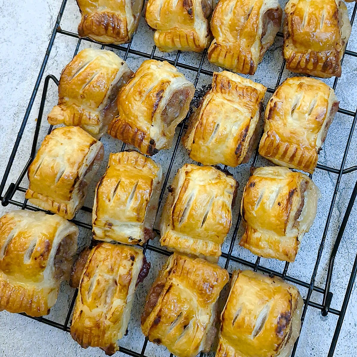 Pork and cranberry sausage rolls cooling on a wire rack.