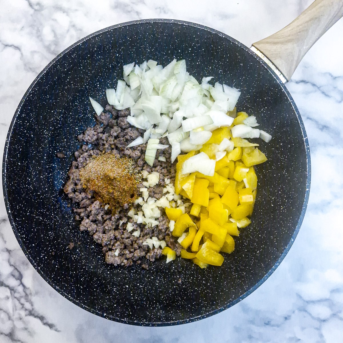 Onions, capsicum and spices added to the browned ground beef.