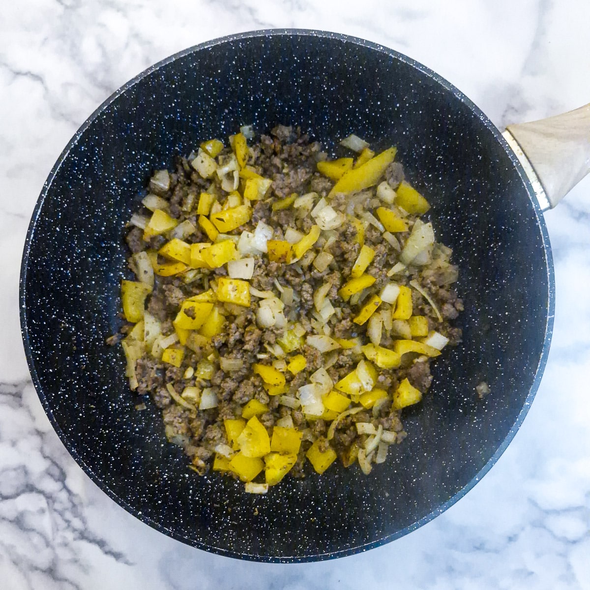 The onions and capsicums after they have been softened in the wok.