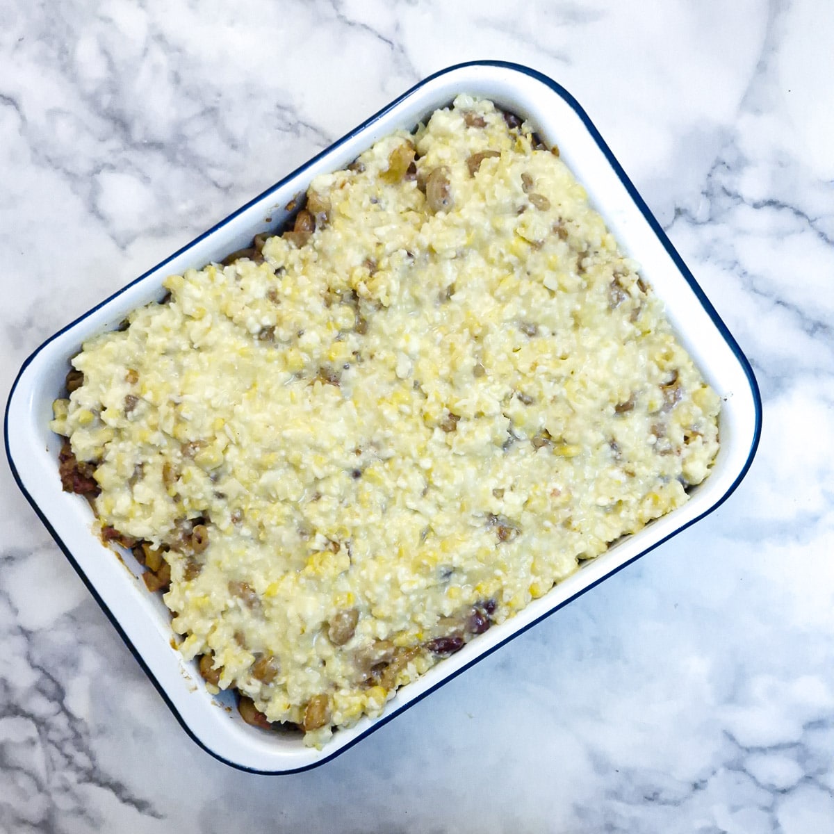 The corn topping spread over the chilli in a baking dish.