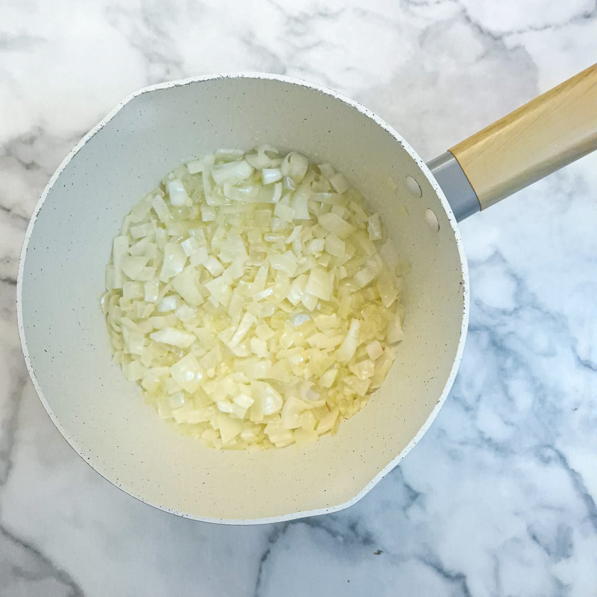 Diced onions softening in butter in a saucepan.
