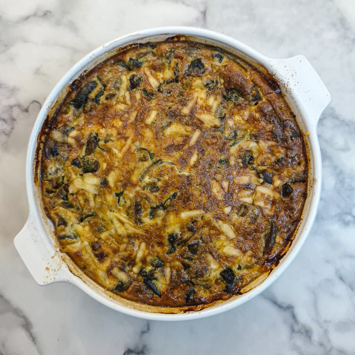 A fully baked mushroom, cheese and spinach crustless quiche.