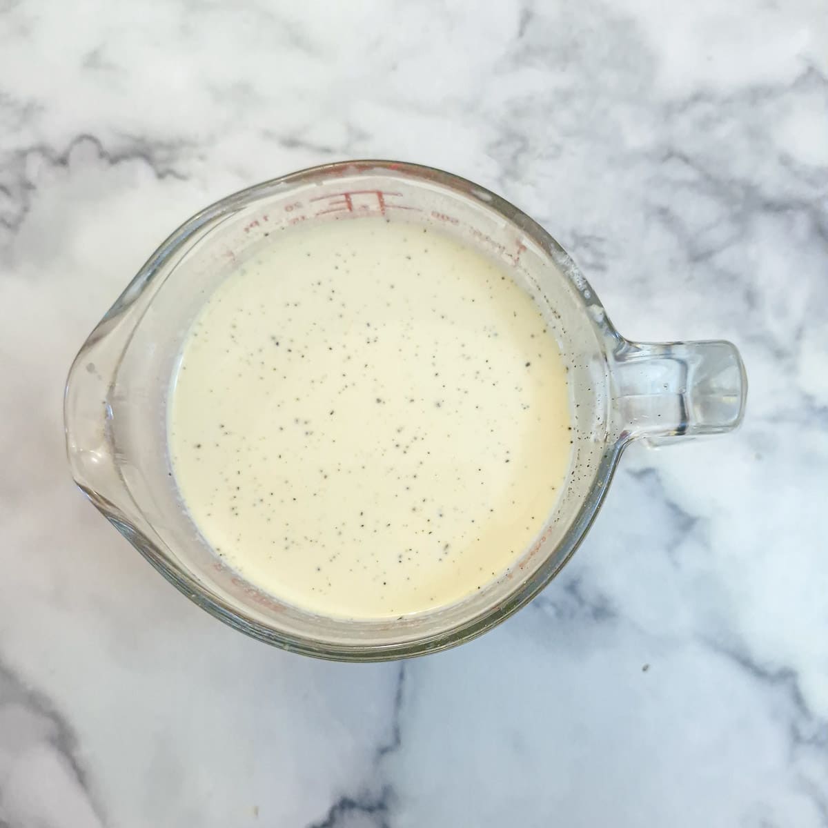 Eggs, cream and mustard whisked together ready to be poured over the quiche filling.