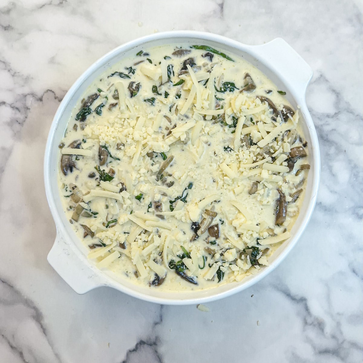 Grated cheese sprinkled on top of the quiche.