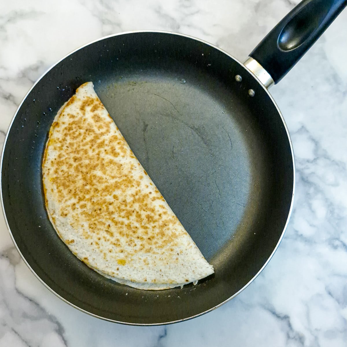 A flour tortilla folded over the quesadilla filling.