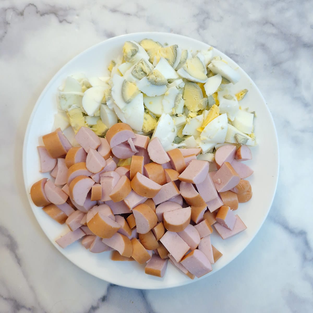 Choppe boiled eggs and bockwurst on a plate.