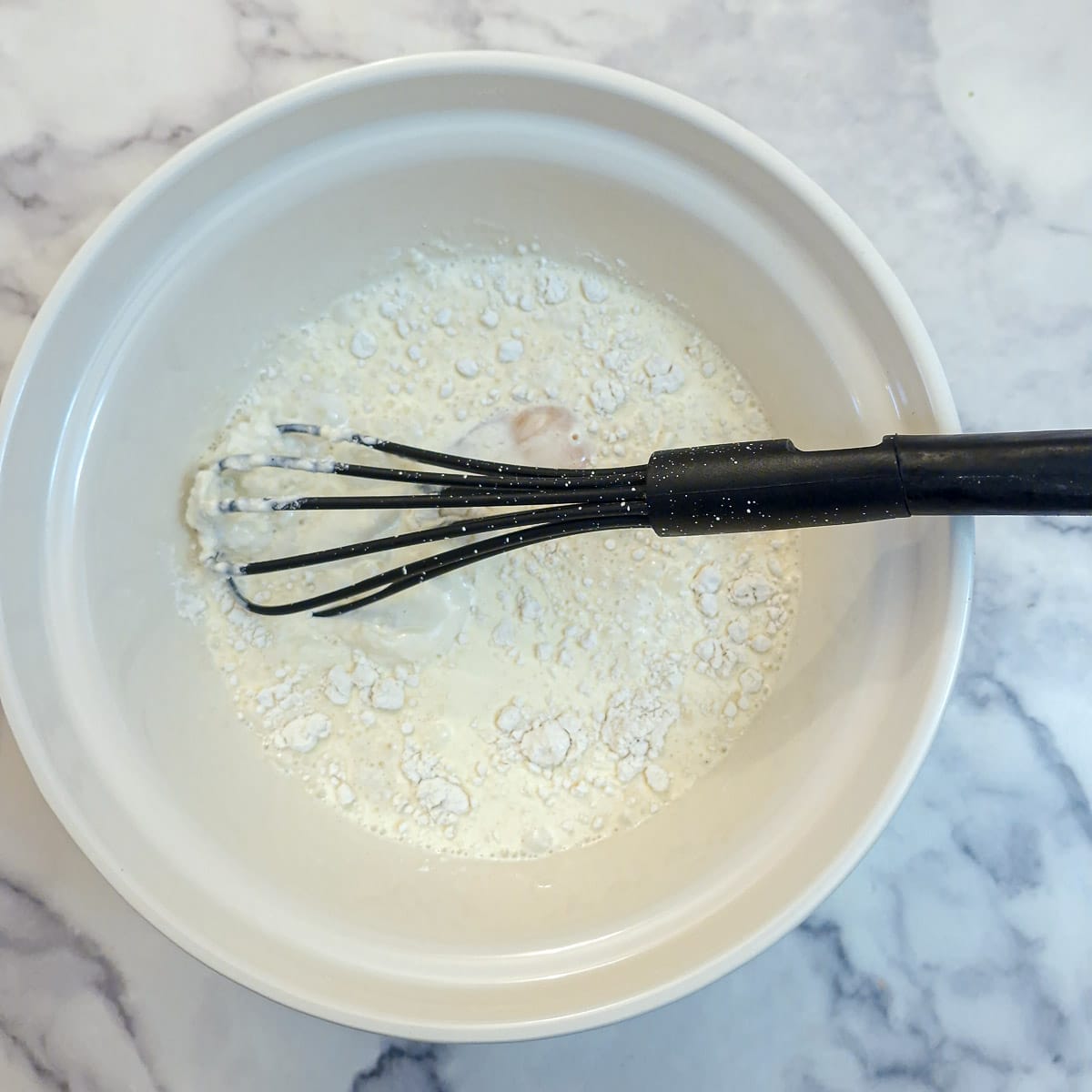 Flour bein whisked into eggs, milk and cream.