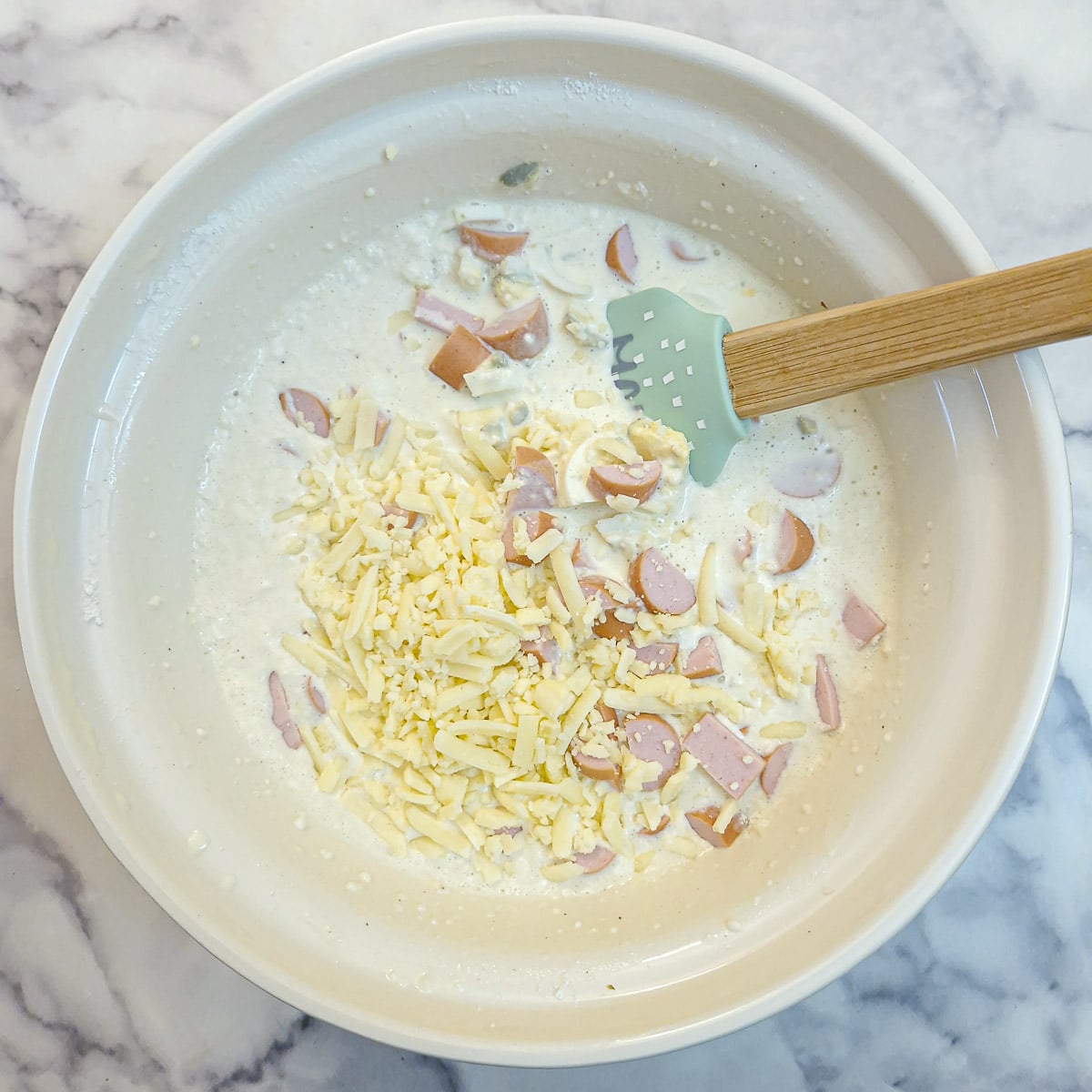 Grated cheese and chopped egg and sausage added into the egg custard mixture.