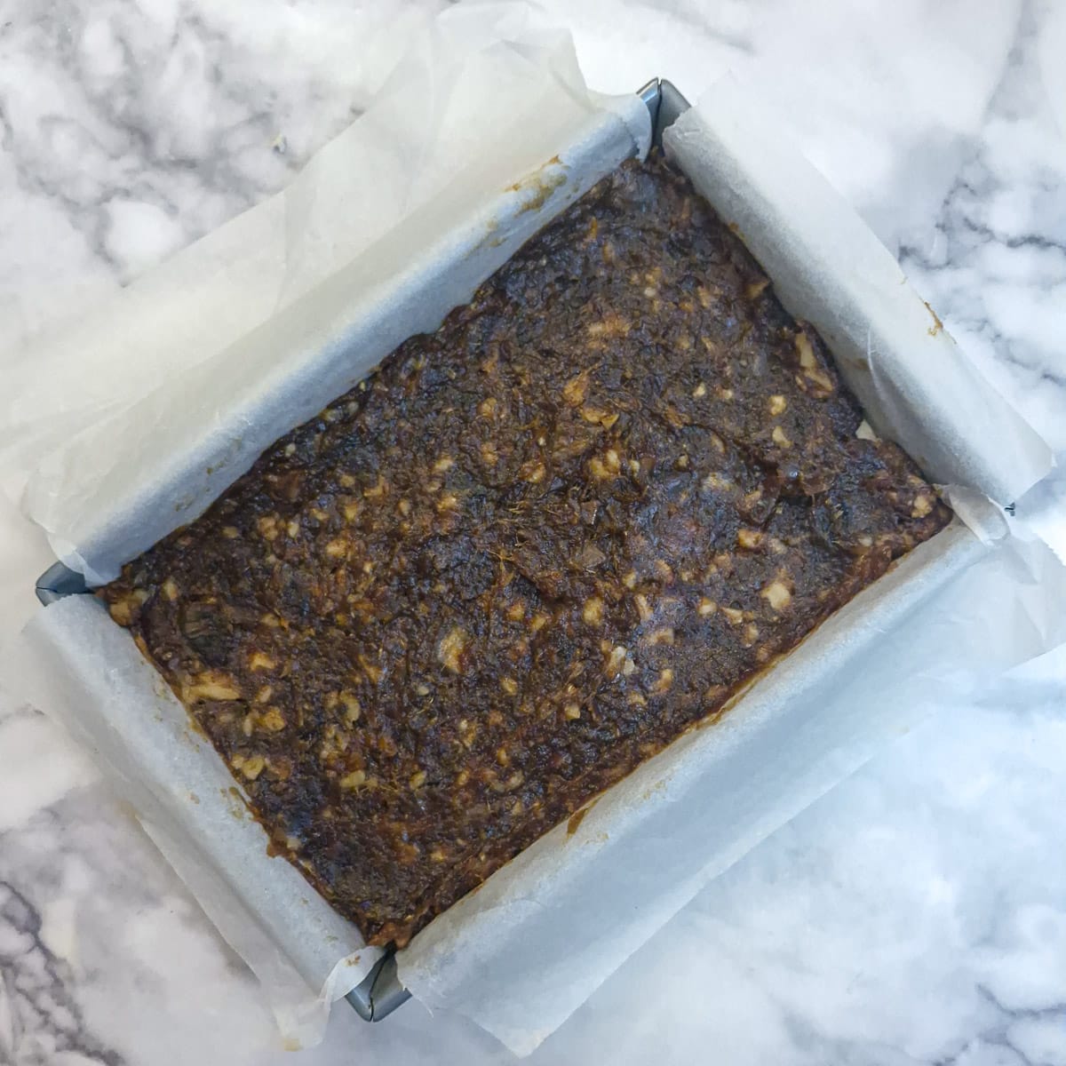 The date mixture spread on top of the pastry in a baking dish.