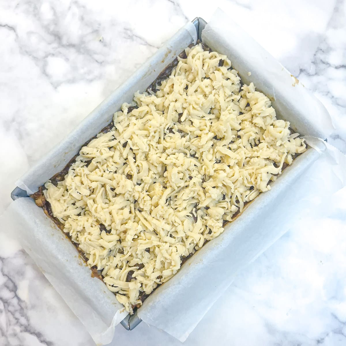 The raw pastry dough that was frozen has been grated on top of the dates.