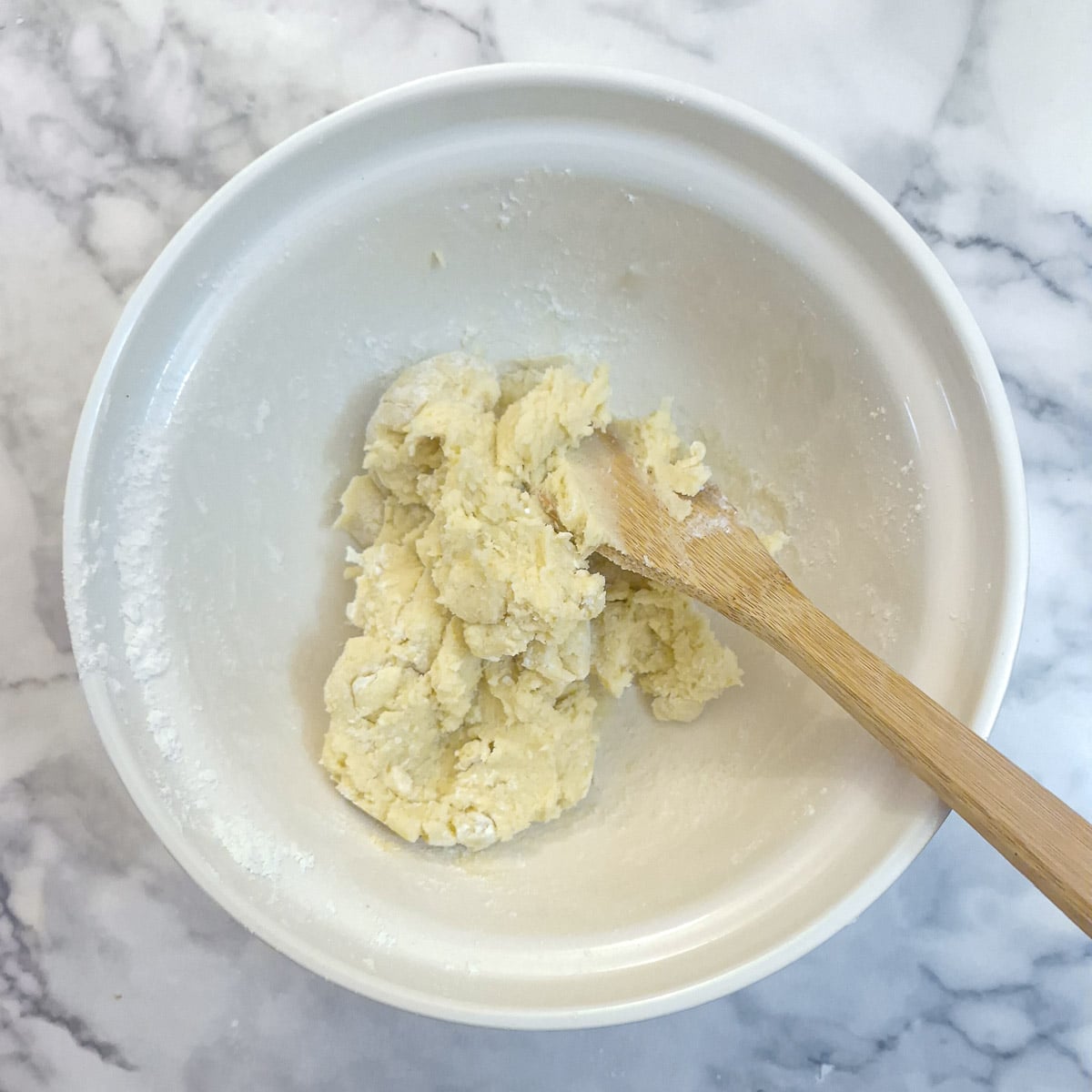 Flour combined with the butter mixture to form a shaggy dough.