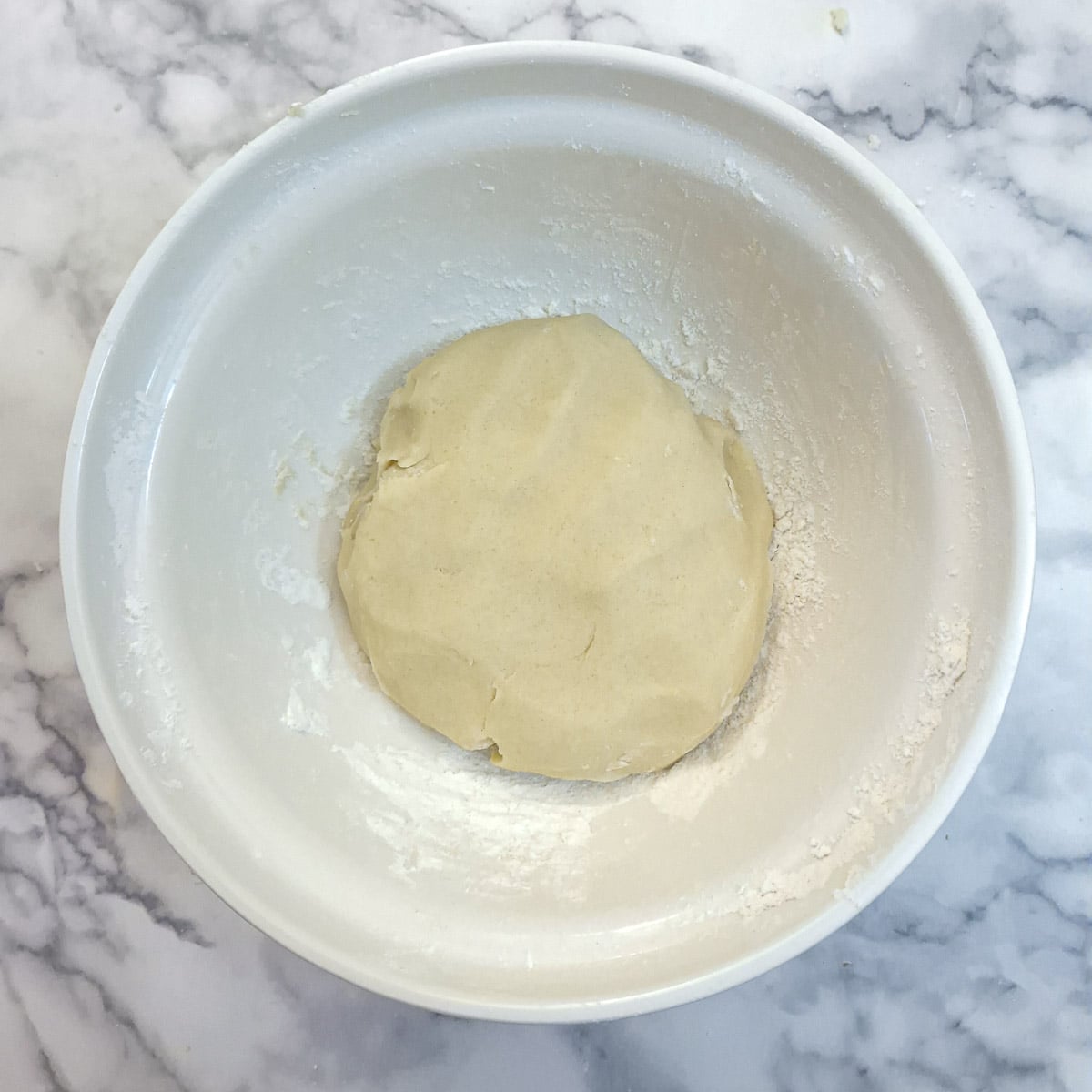 A ball of soft dough in a mixing bowl.