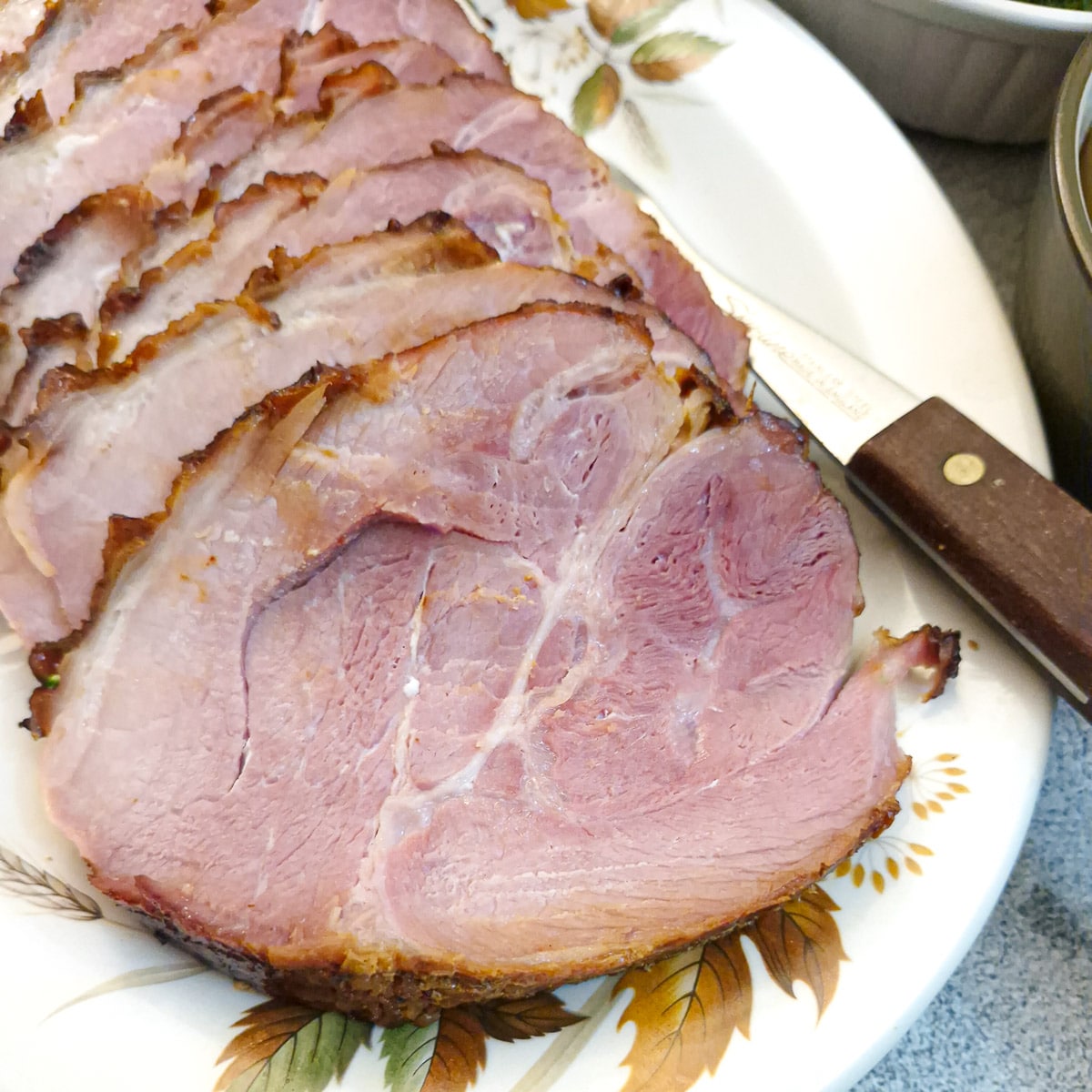 Slices of honey-glazed ham on a serving plate.