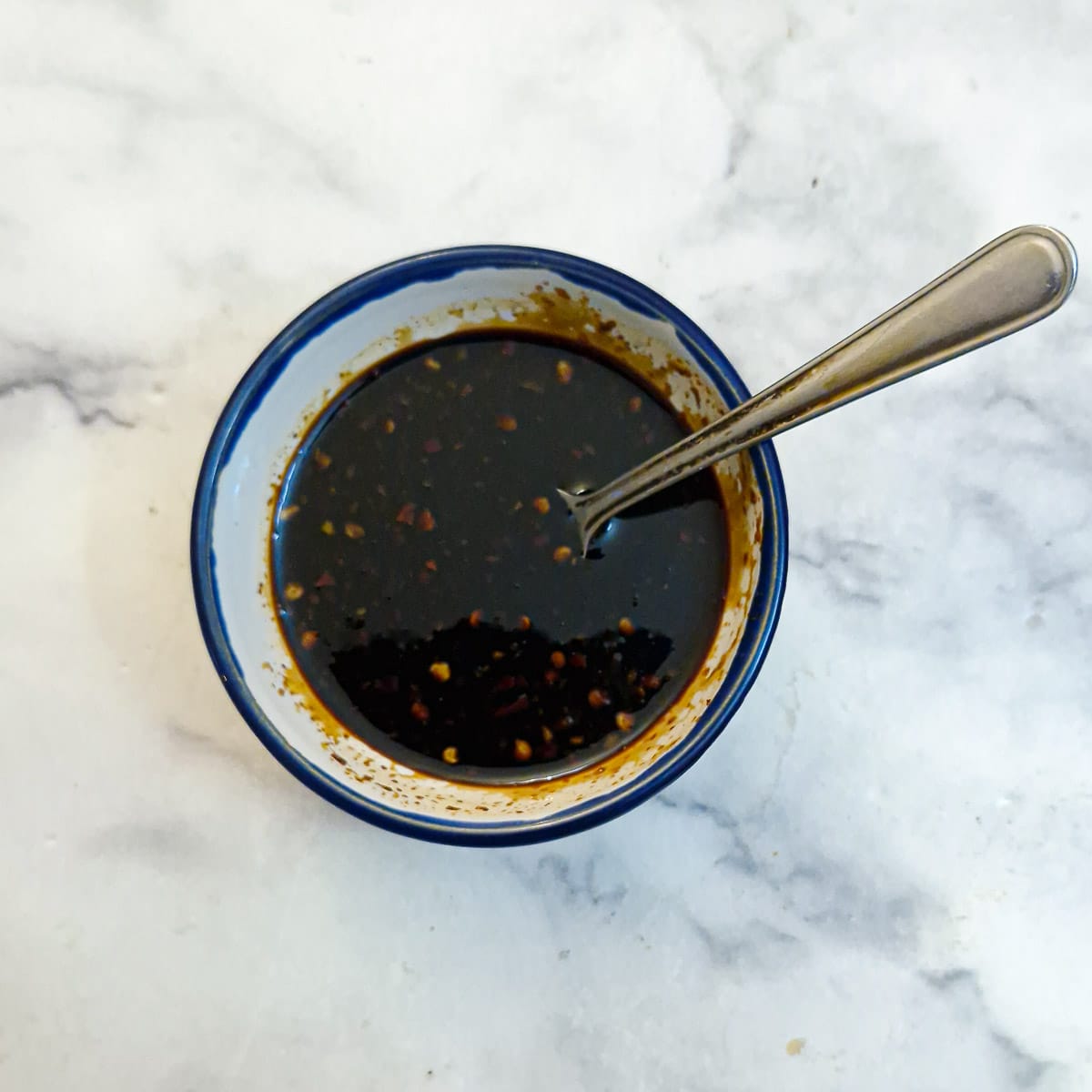 Honey glaze in a small blue-rimmed bowl.