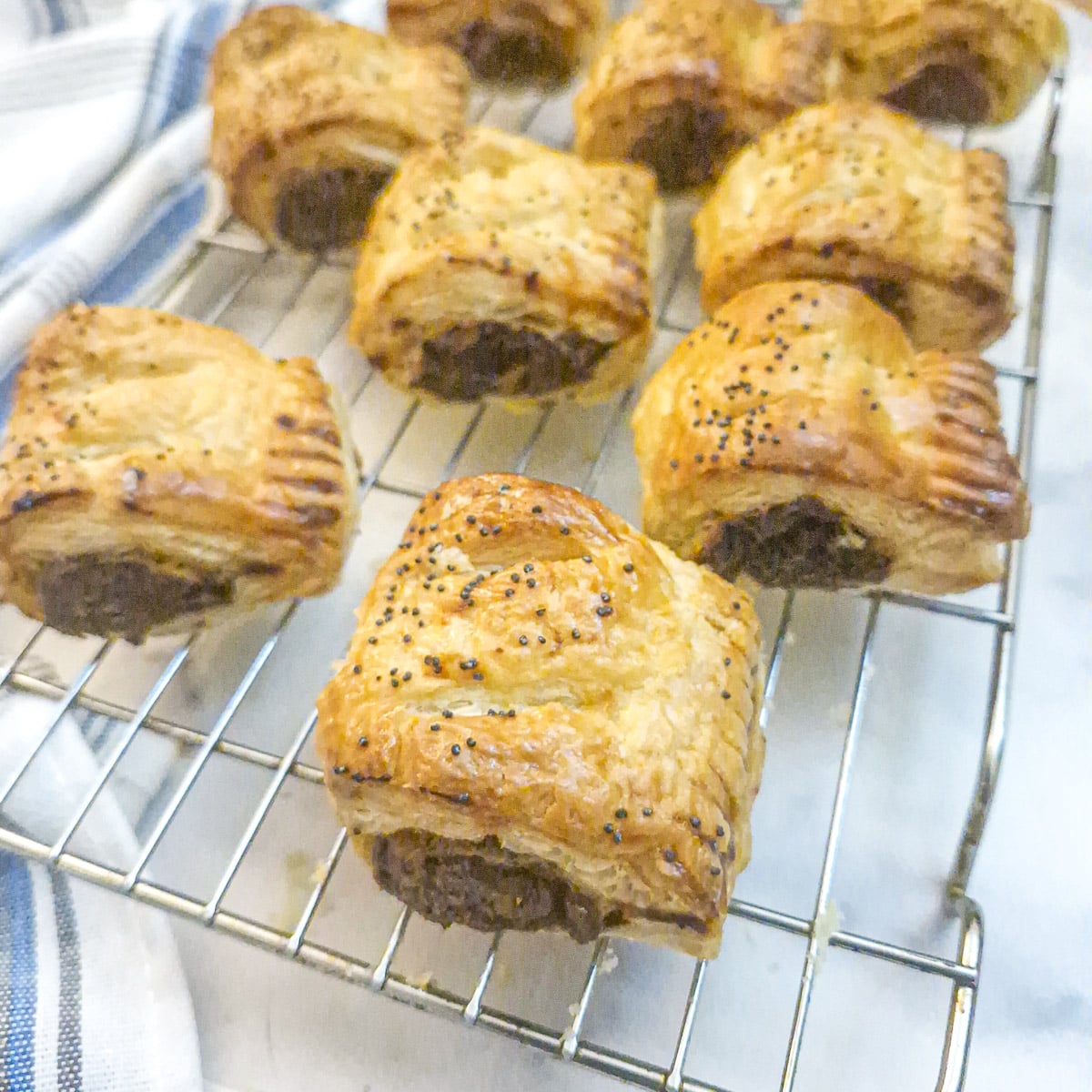 Mushroom-filled sausage rolls on a wire cooling rack.