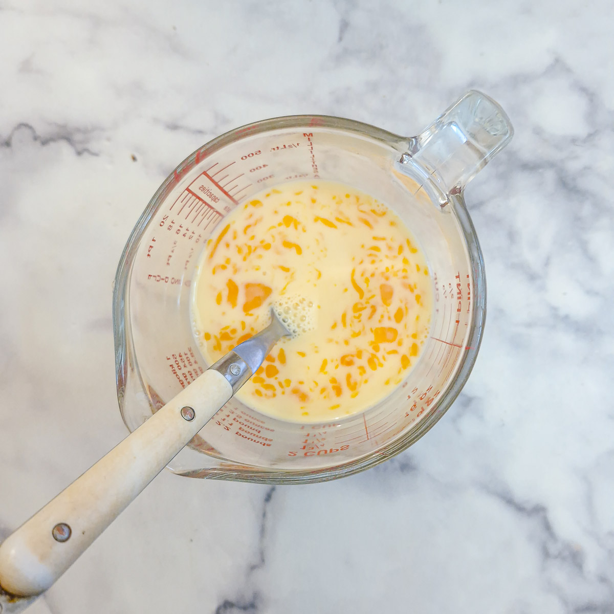 Beaten egg and milk in a glass
measuring jug with a fork.