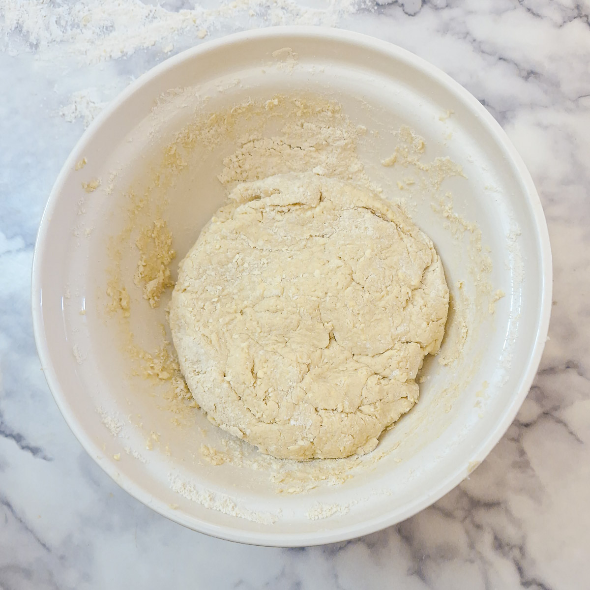 The cheese scone dough pressed together in a mixing bowl into a soft dough.