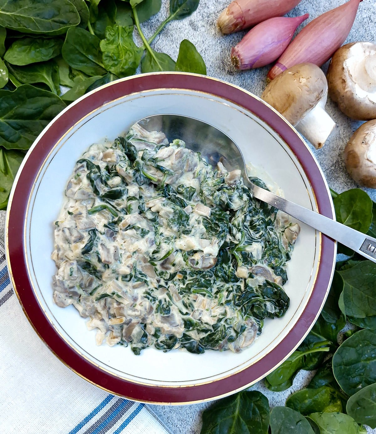Creamed spinach in a serving dish with a serving spoon.